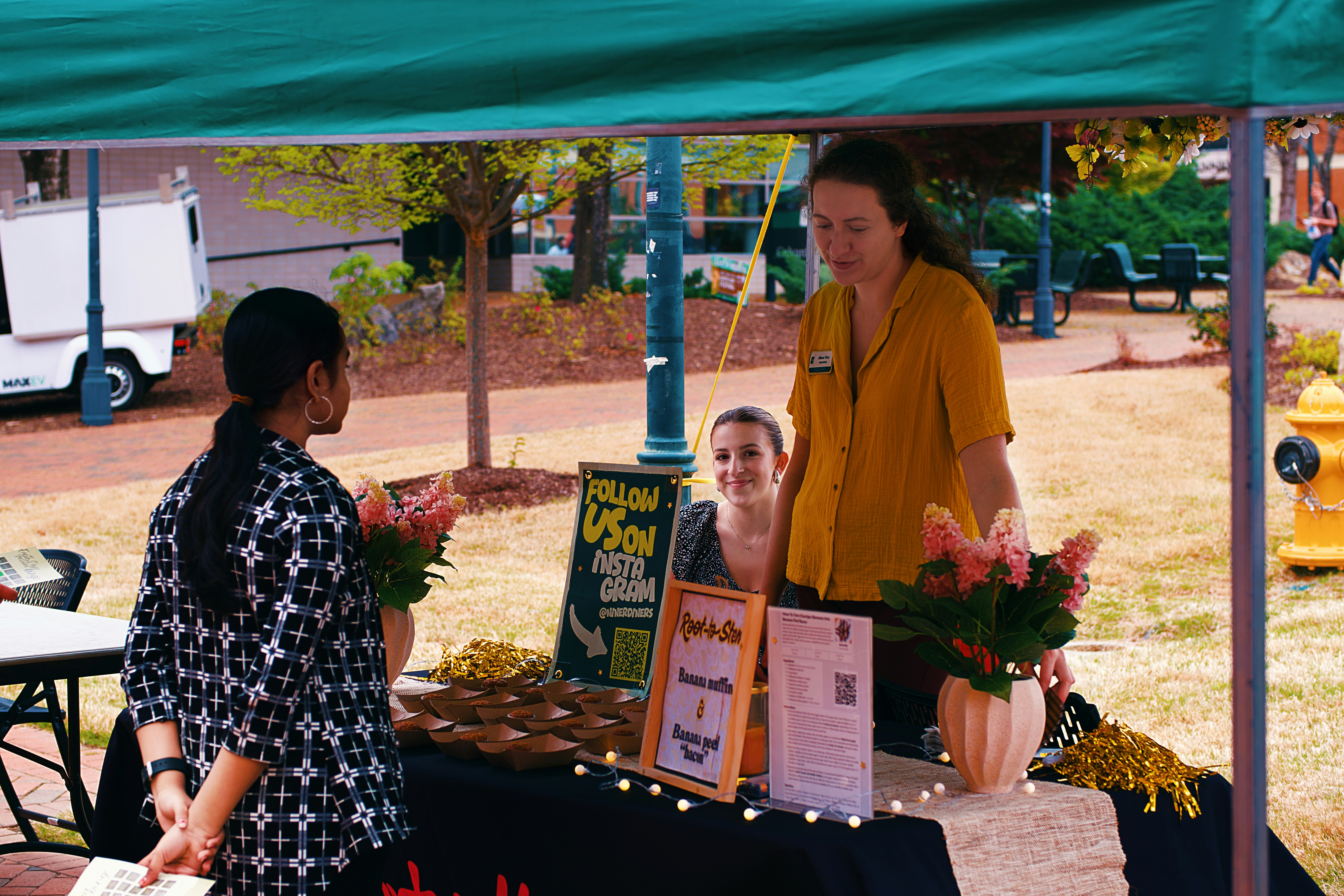 of a local business owner engaging with community members at a local farmers market or event. - local business branding