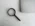 Magnifying glass sits near a laptop on a table