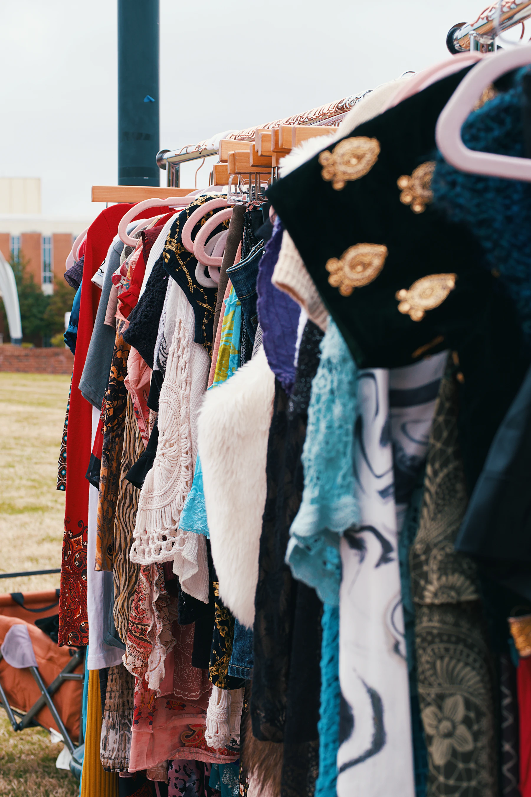 Clothing hangs on racks, likely at a market