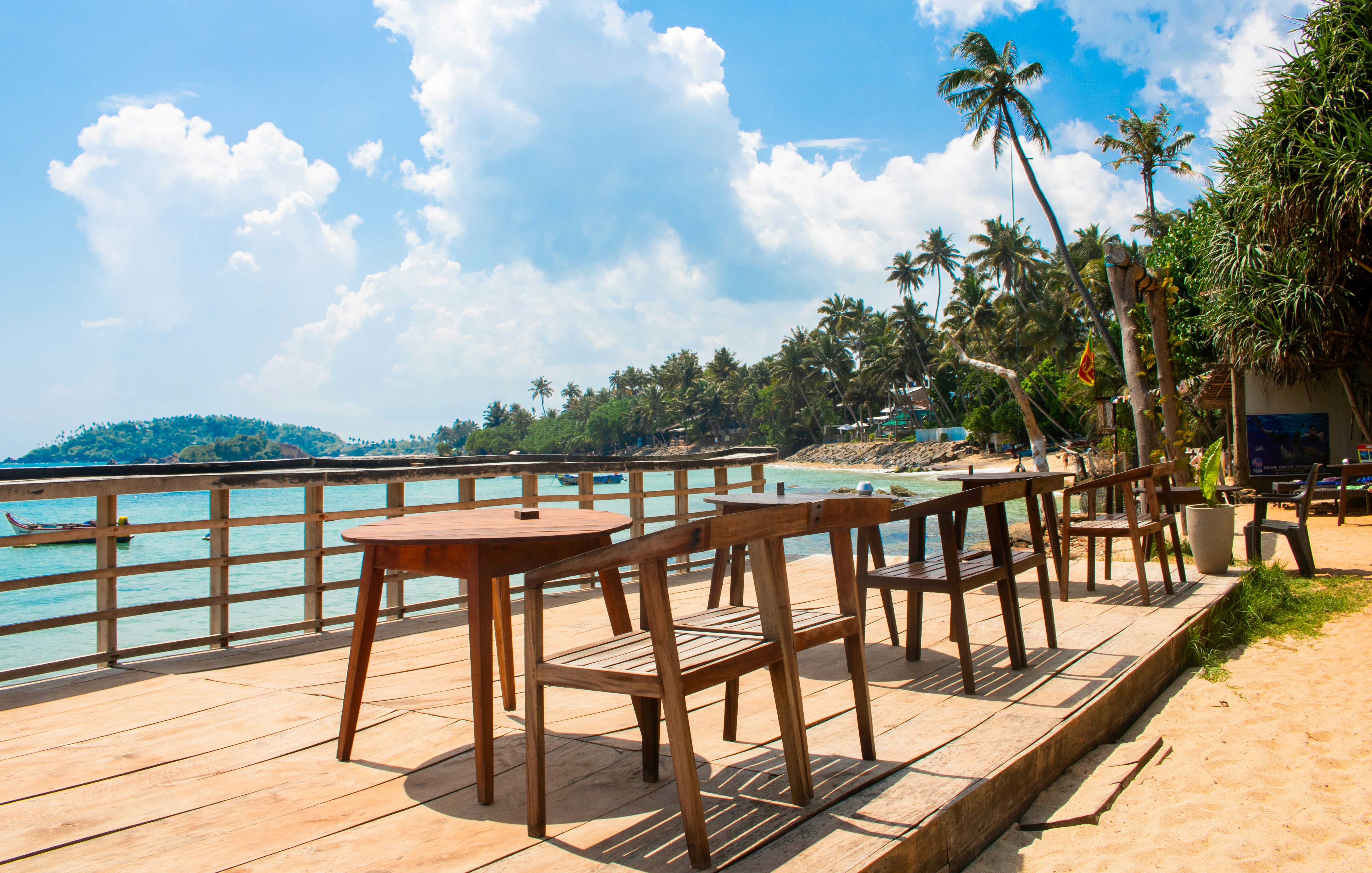 Terrasse de café ensoleillée avec vue sur la plage et l océan turquoise
