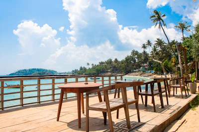 Outdoor dining area with an ocean view, evoking an upscale cliffside restaurant terrace