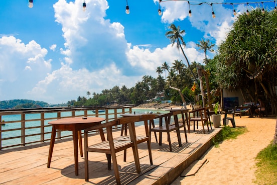 A tropical beach cafe sits by the ocean.