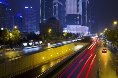 Nighttime cityscape with light trails and skyscrapers.