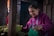 A woman arranges lettuce at a market.