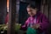 A woman arranges lettuce at a market.