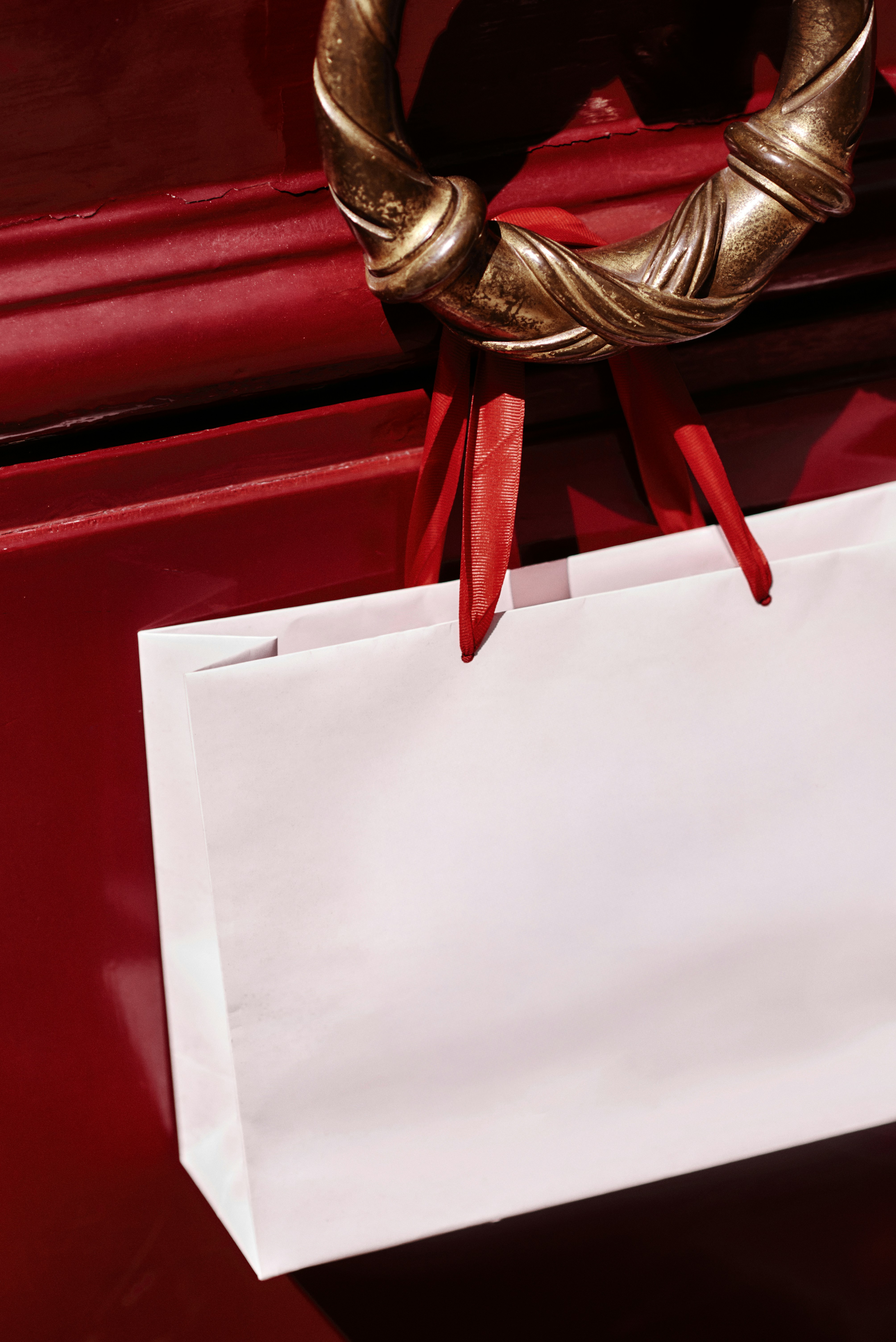 Una borsa della spesa è appesa alla maniglia di una porta.