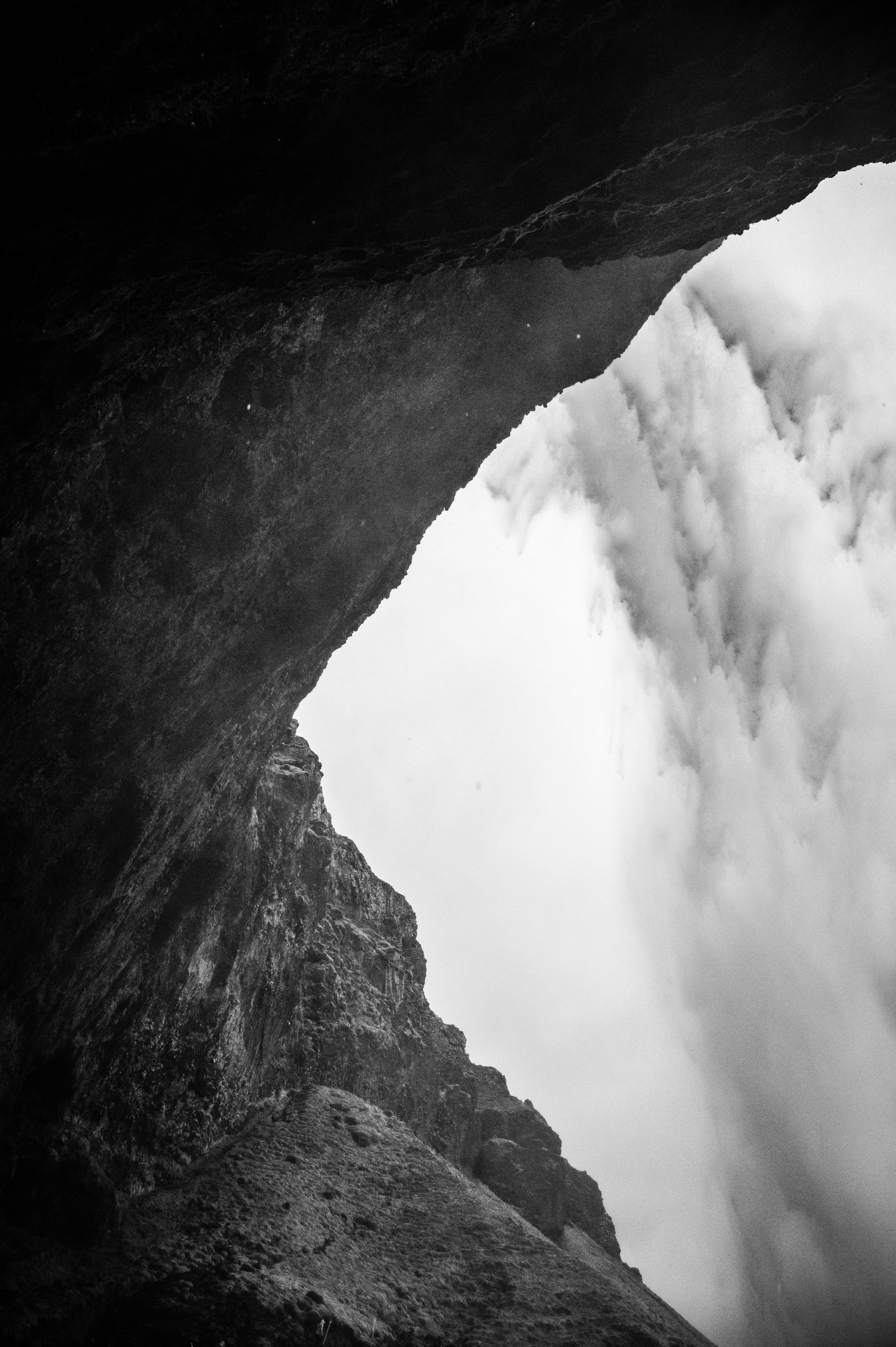 Waterfall seen from within a dark cave.