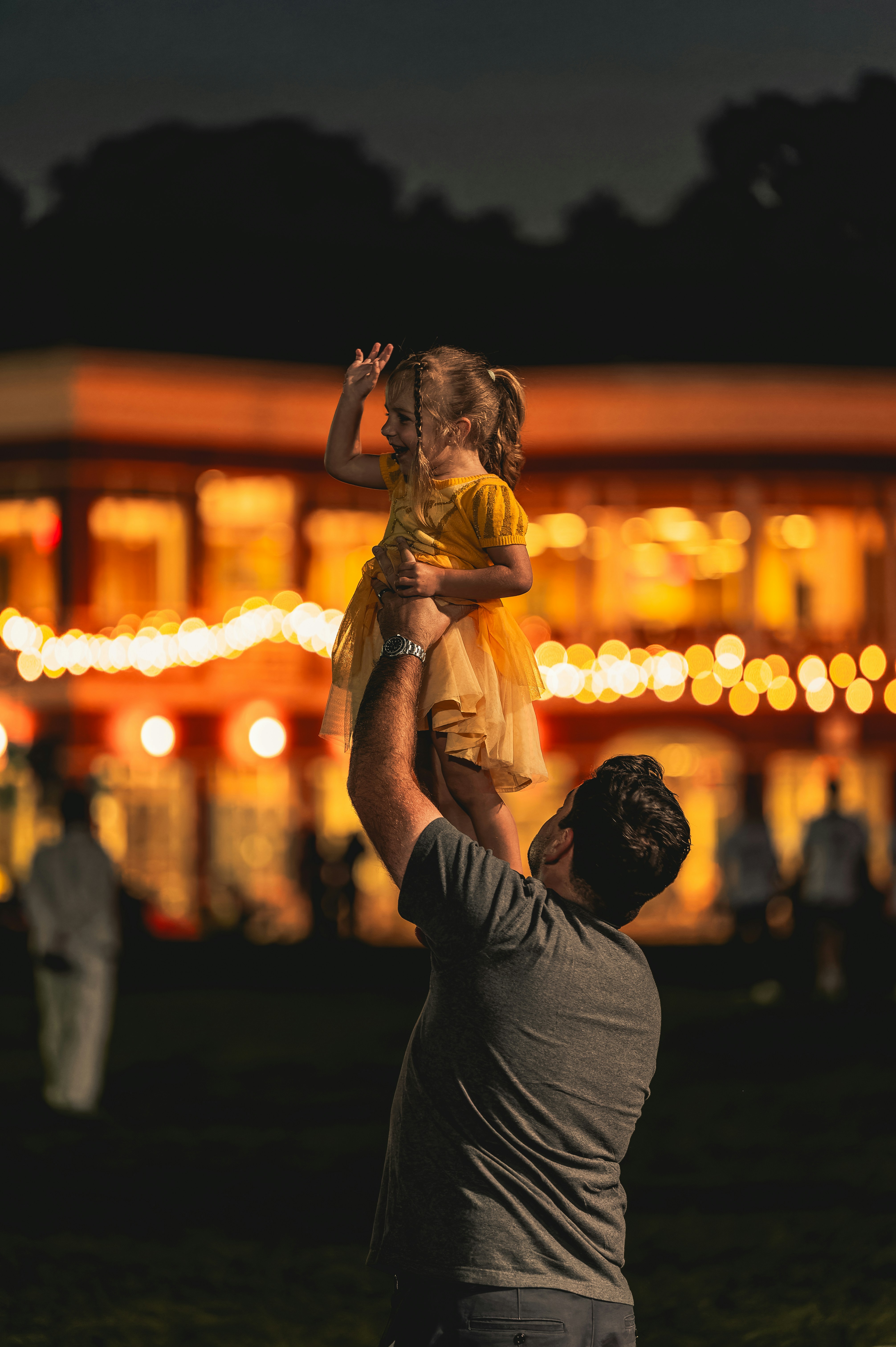 A father lifts his child in the evening.