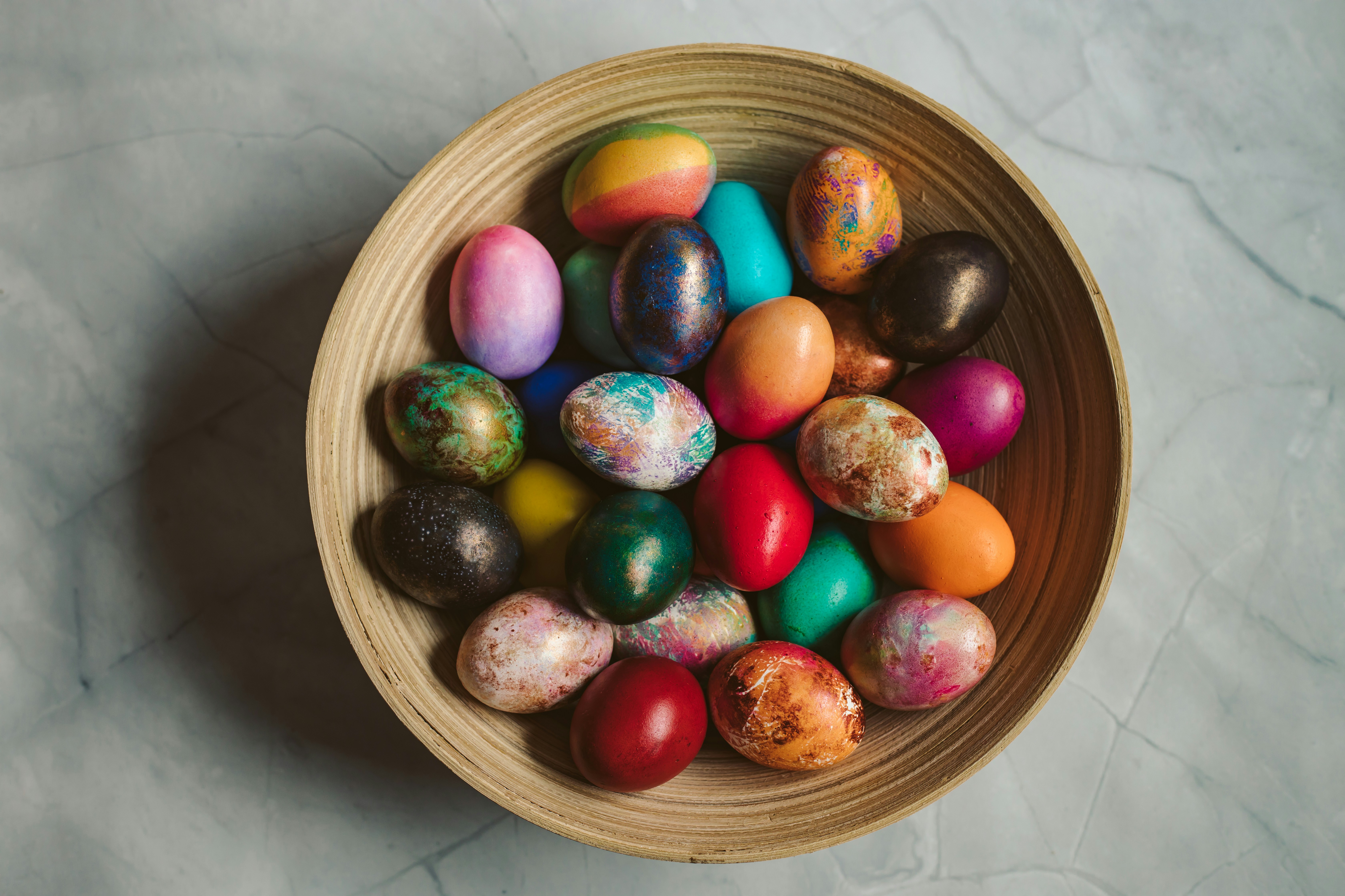 A bowl filled with colorful easter eggs.