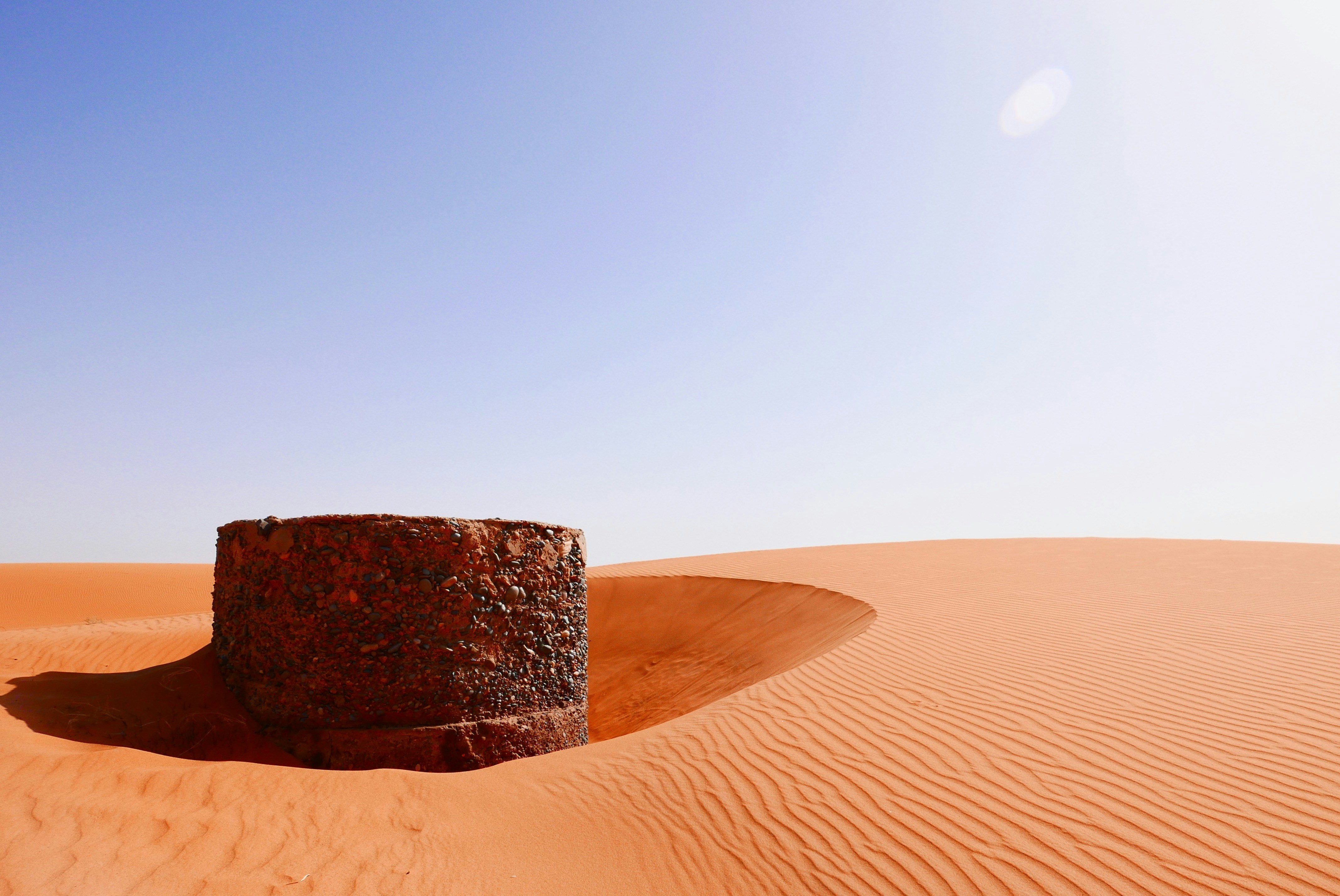 Ancient ruins stand amidst the vast desert dunes.