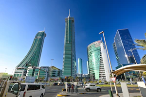 Modern skyscrapers rise against a brilliant blue sky.