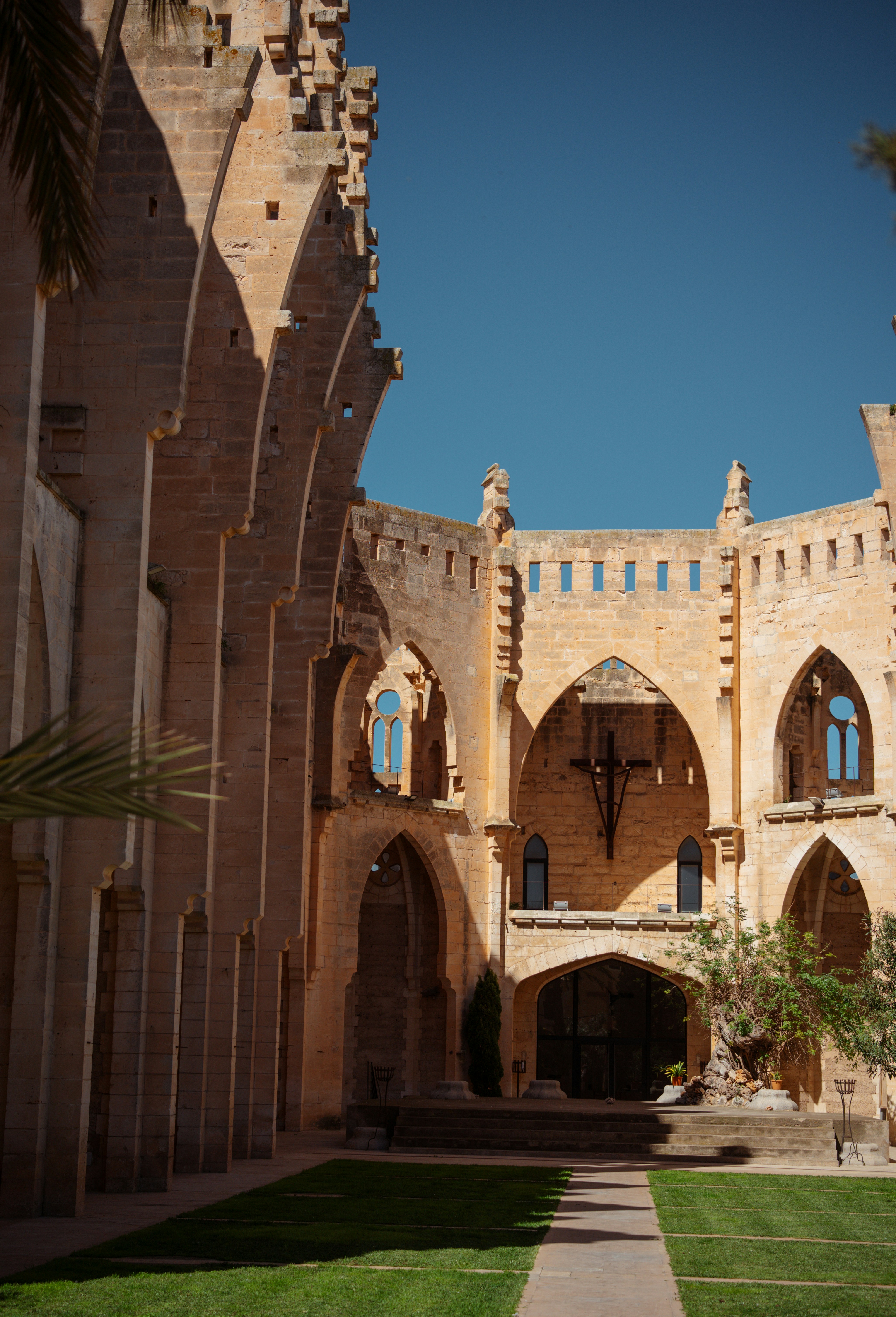 An ancient, gothic courtyard is bathed in sunlight.