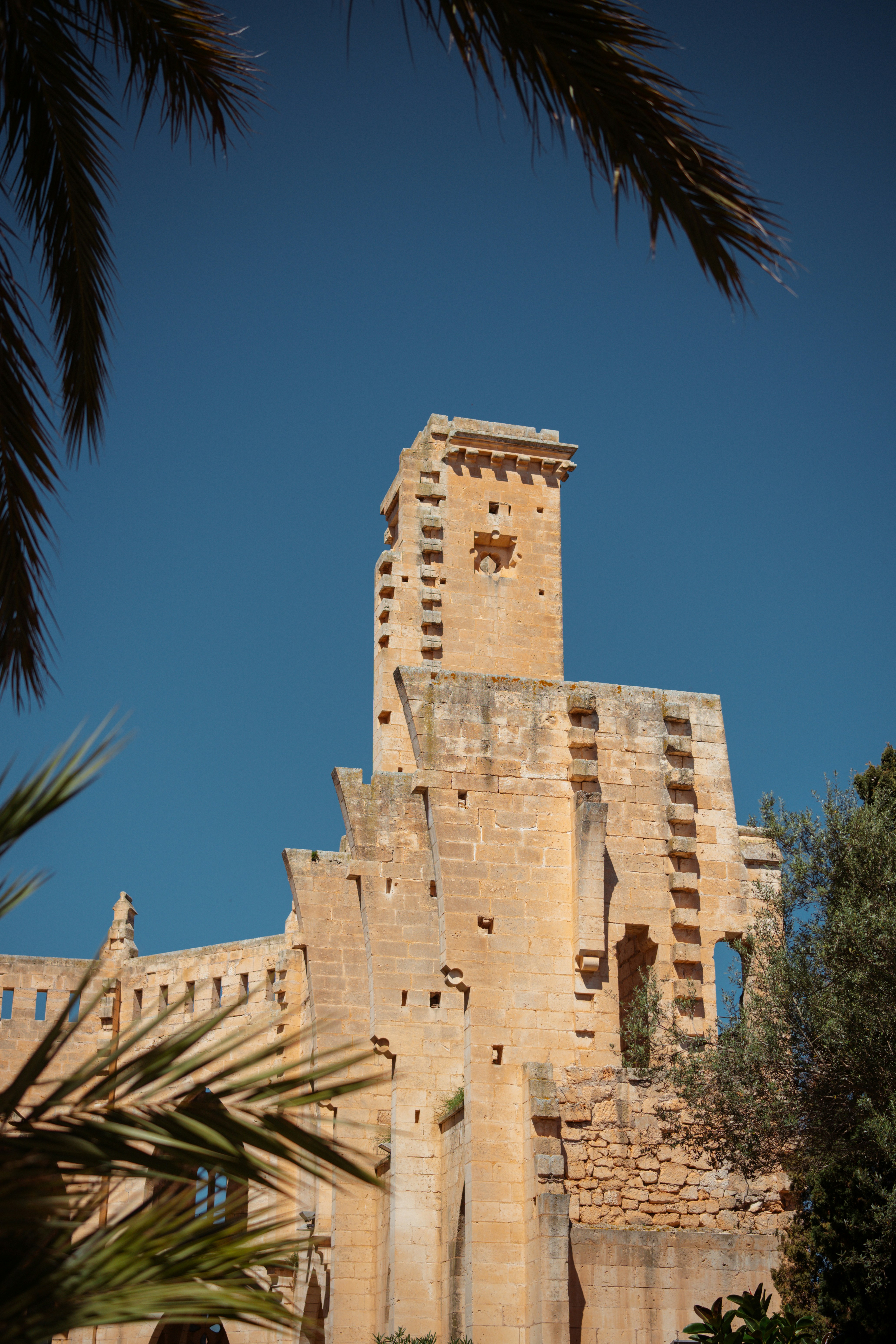Ancient, weathered building stands under a clear, blue sky.