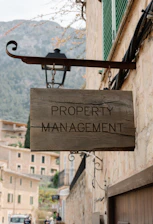 Property management sign hangs on a building.