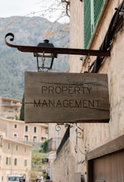 Property management sign hangs on a building.
