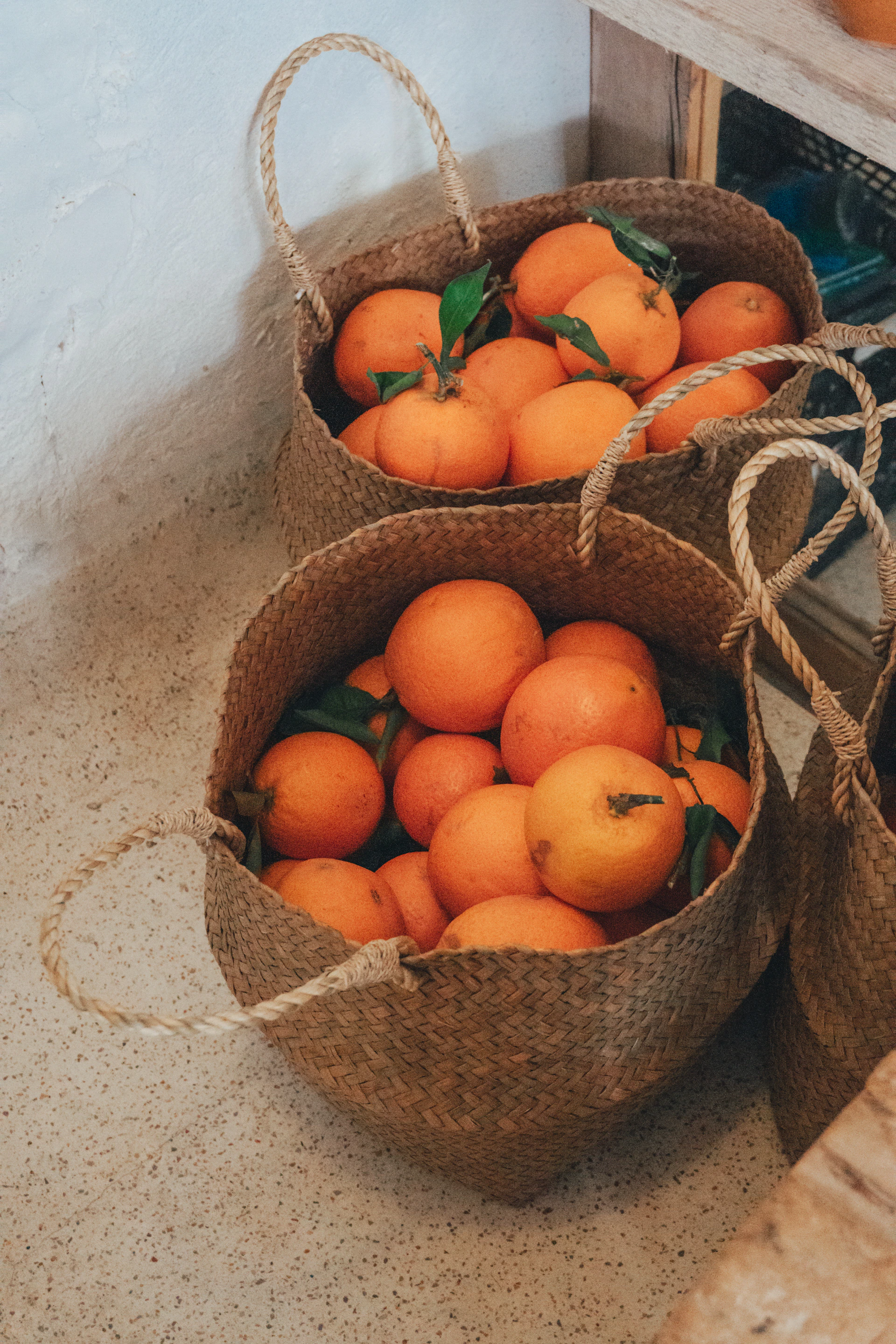 Baskets are filled with fresh, ripe oranges.