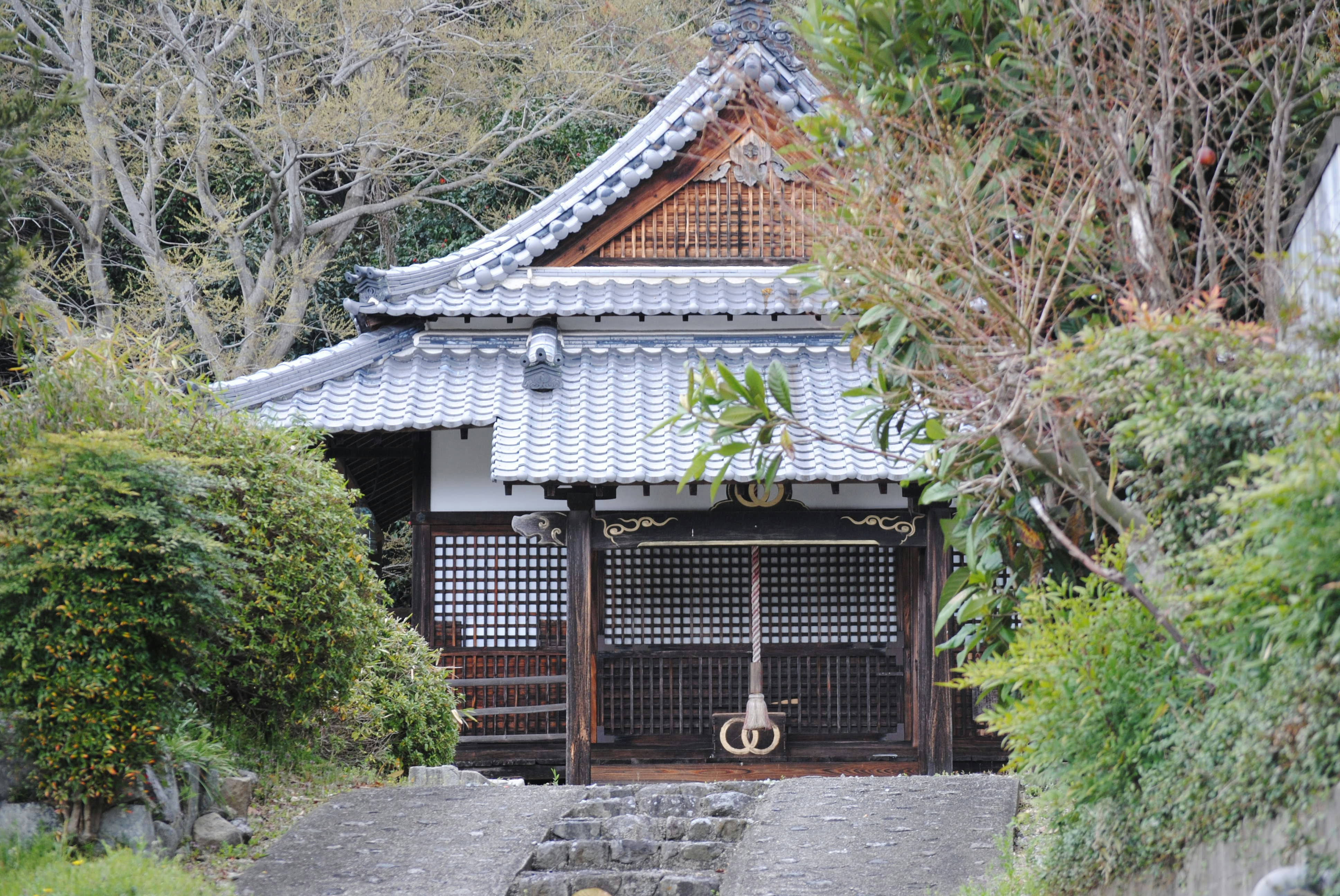 A traditional japanese temple stands among the trees.