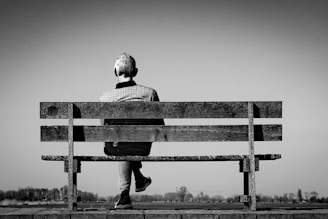 A person sits alone on a bench.