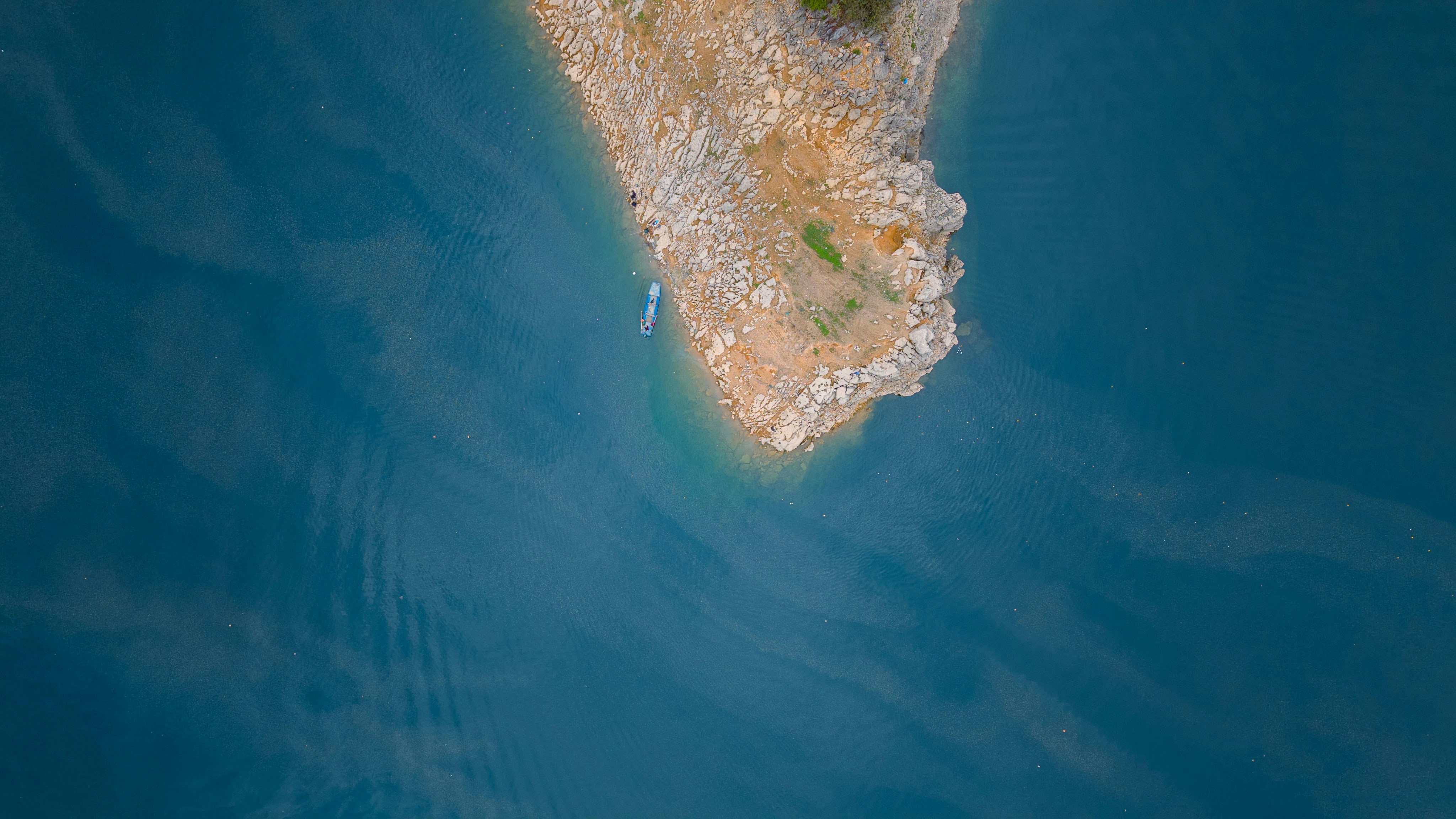 A rocky island surrounded by calm, blue water.