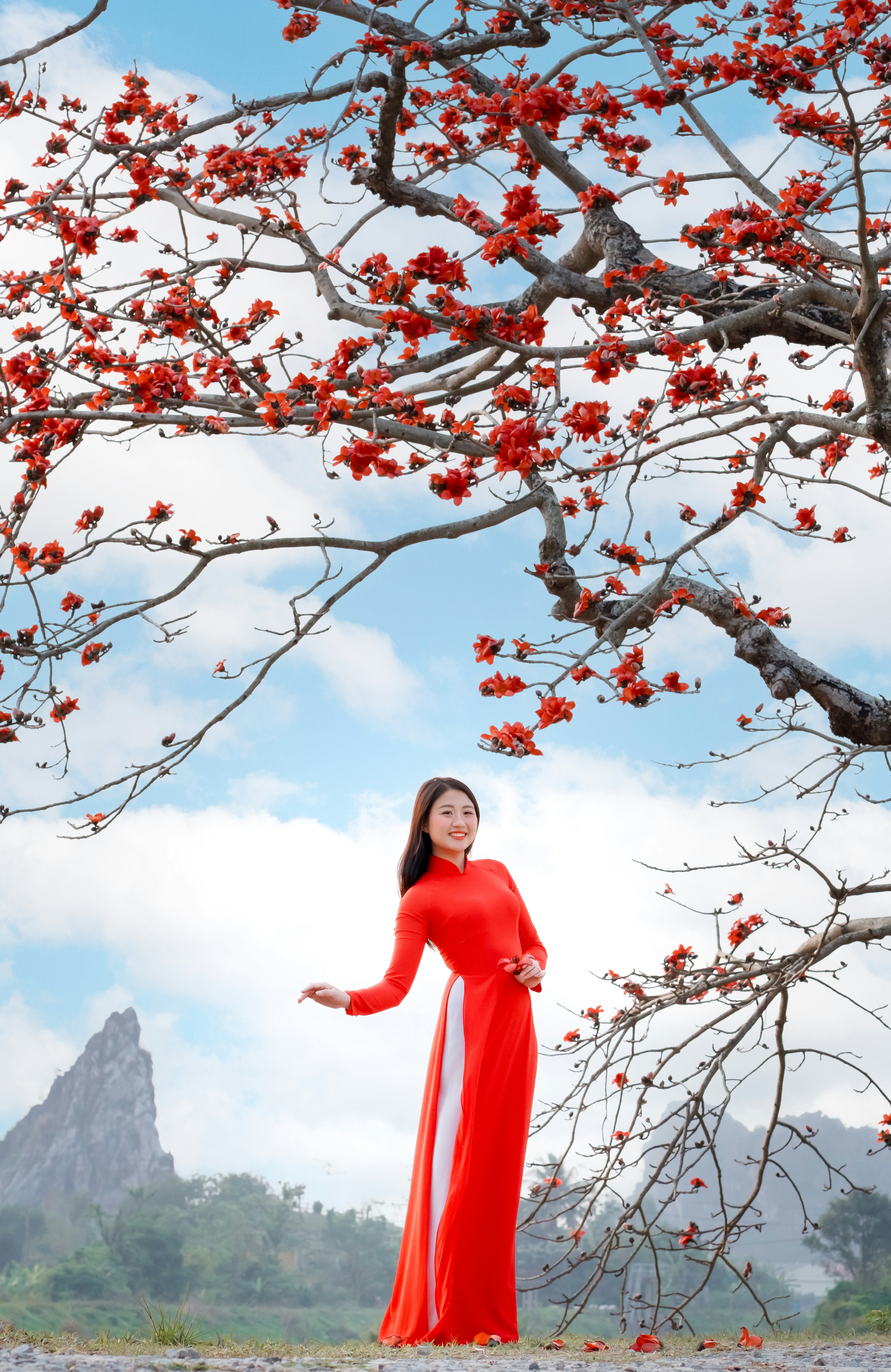 Woman poses under a blooming tree in a red dress. photo – Free Woman ...