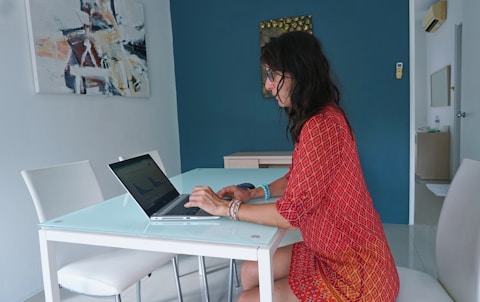 Woman works on laptop at a table.