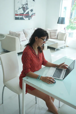 Woman works on her laptop at a table.