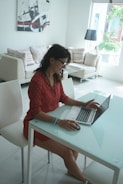 Woman works on a laptop at her home.