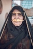 An older woman wears traditional middle eastern clothing.