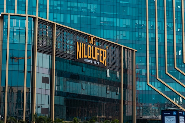 A modern building with a cafe niloufer sign.