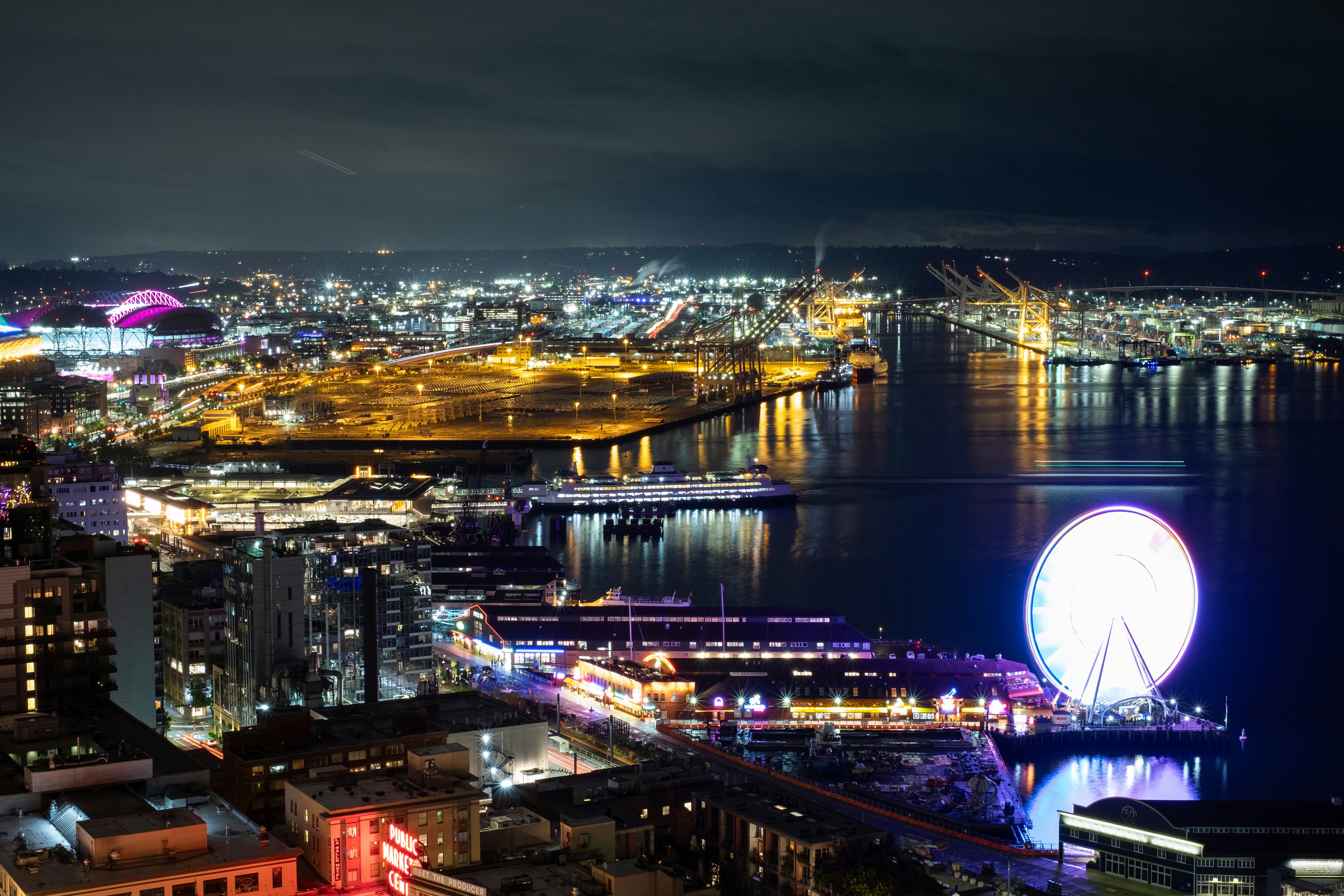Night view of a city skyline by the water.