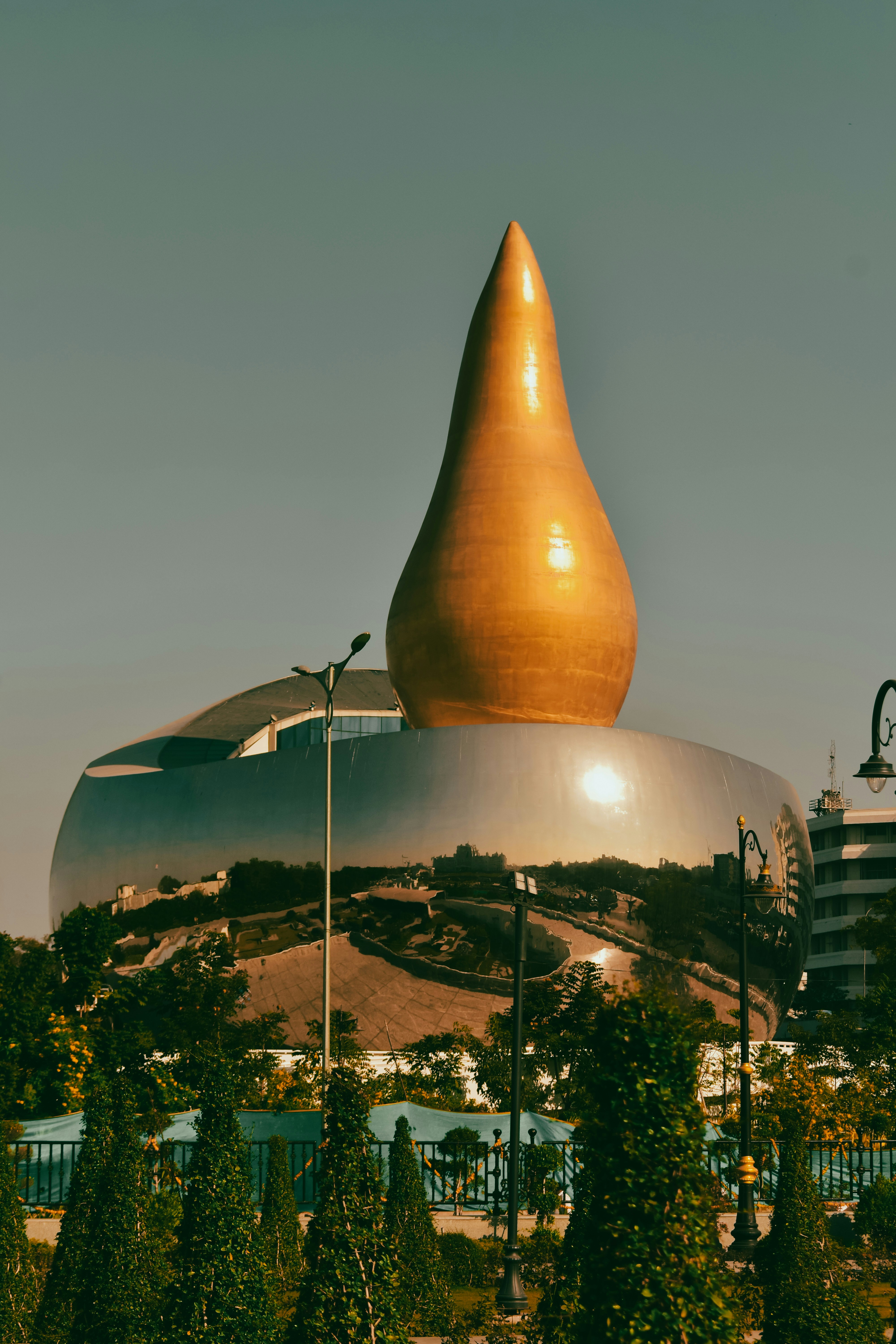 A unique, golden-topped building reflects the surroundings.