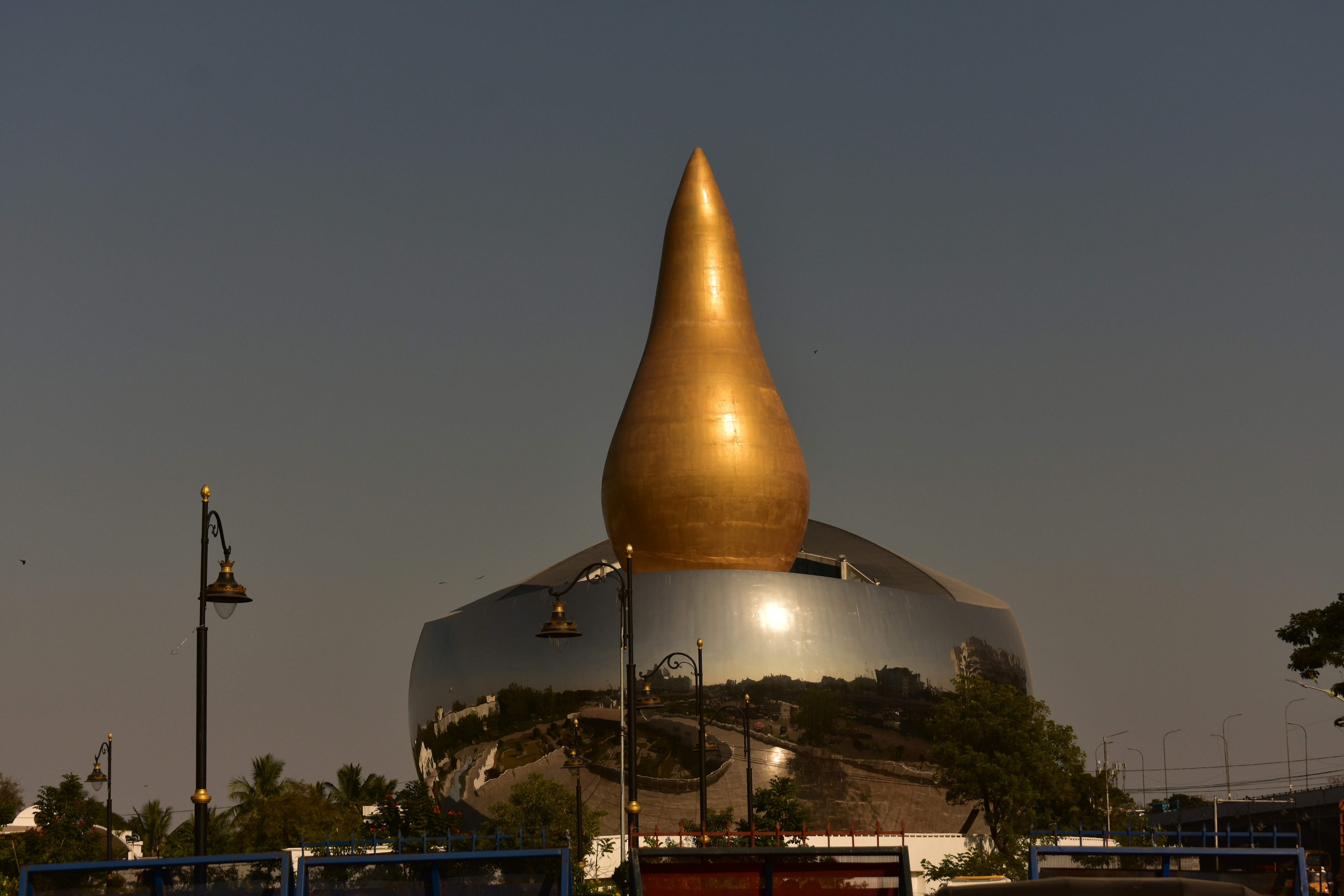 A golden-topped building reflects the sky.