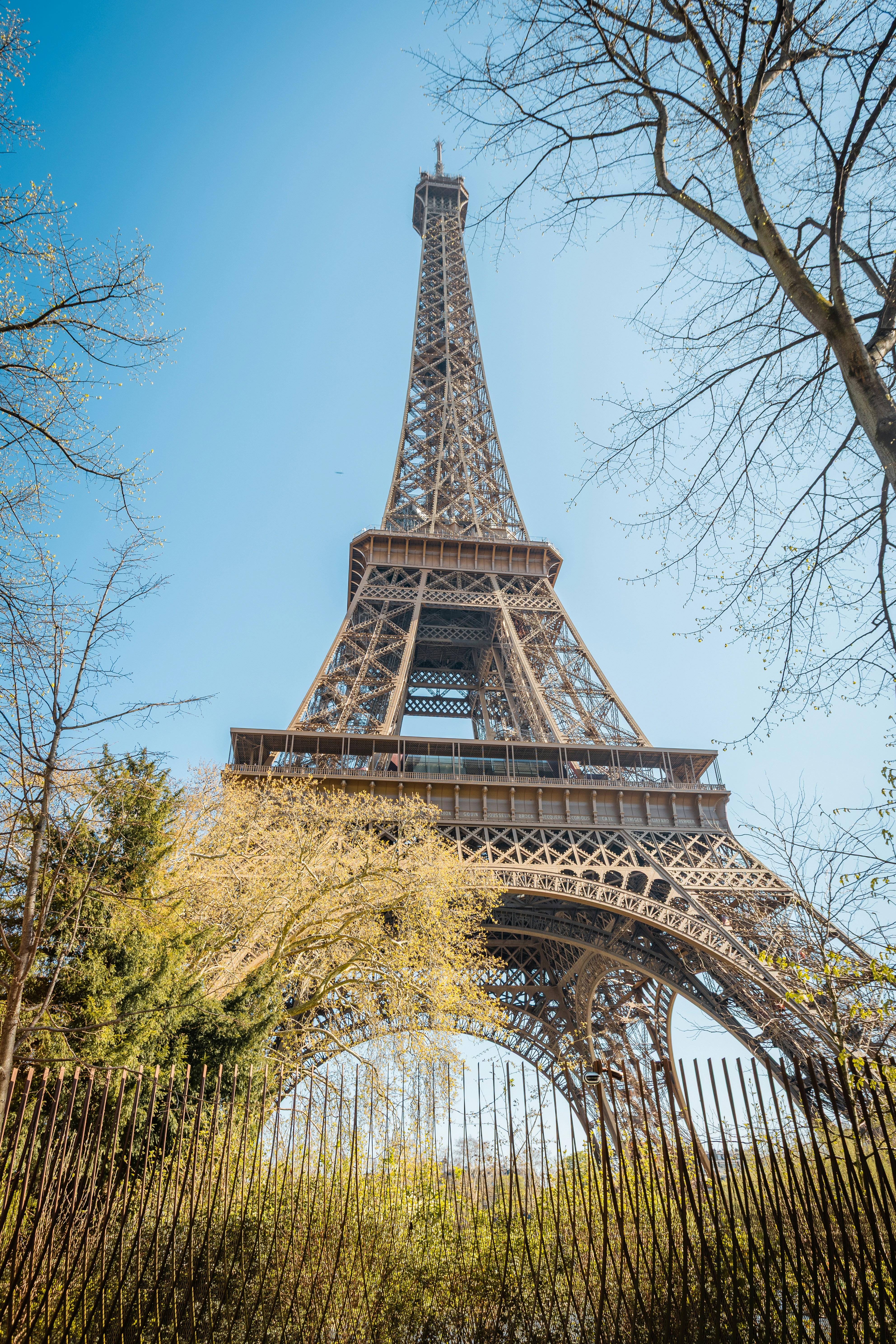 The eiffel tower stands tall under a bright blue sky