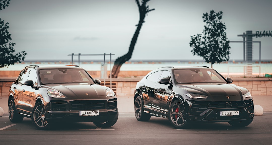 Two luxury suvs sit side by side.,
