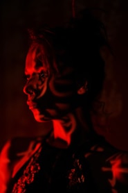 A woman's face is illuminated with red light.
