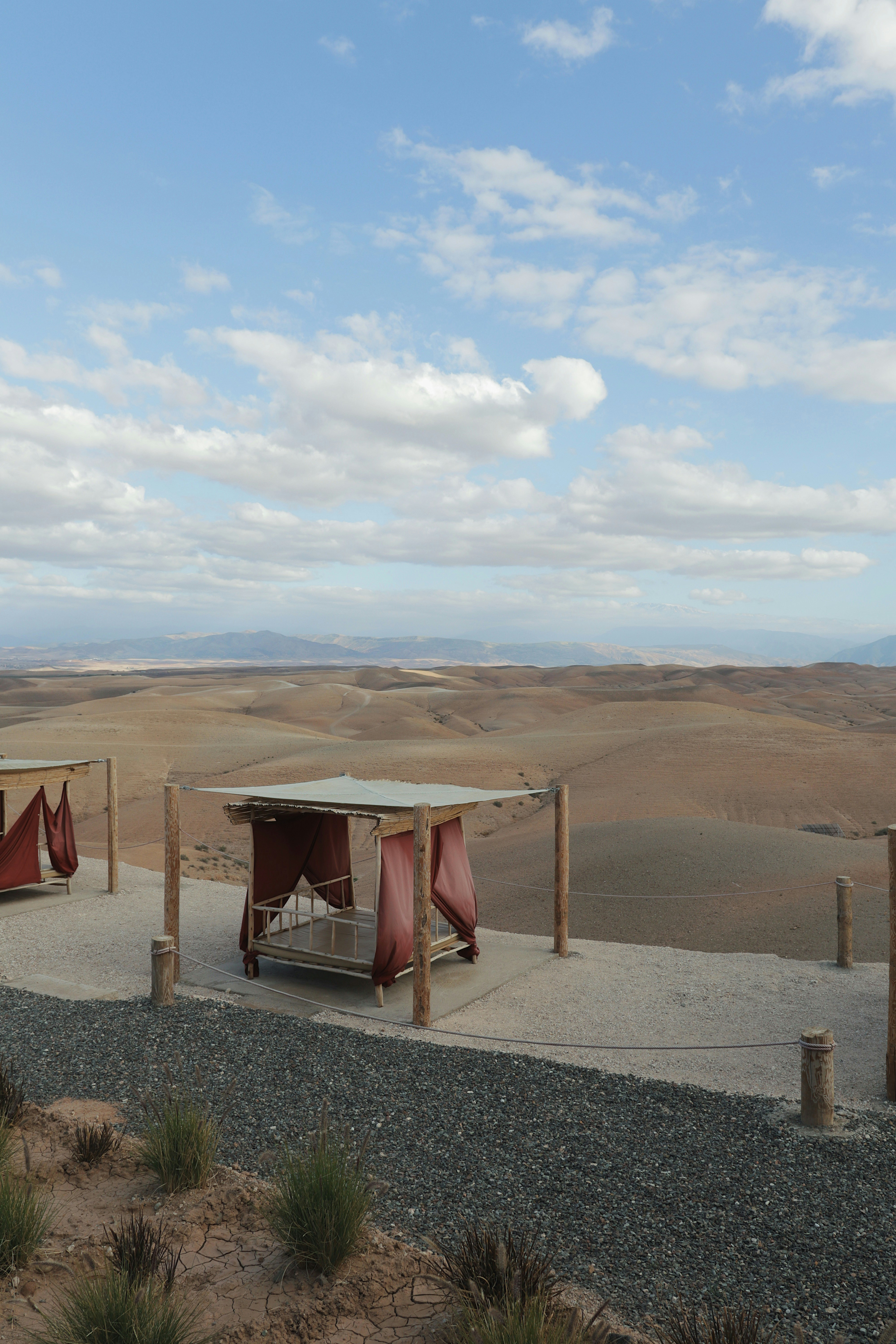 Beds overlook a vast, arid landscape under a blue sky.