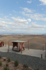 Beds overlook a vast, arid landscape under a blue sky