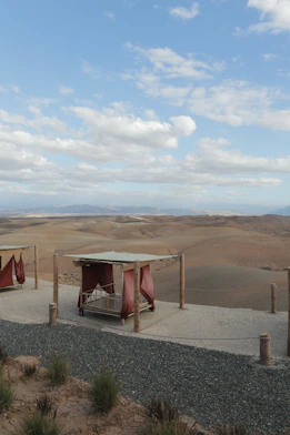 Beds overlook a vast, arid landscape under a blue sky