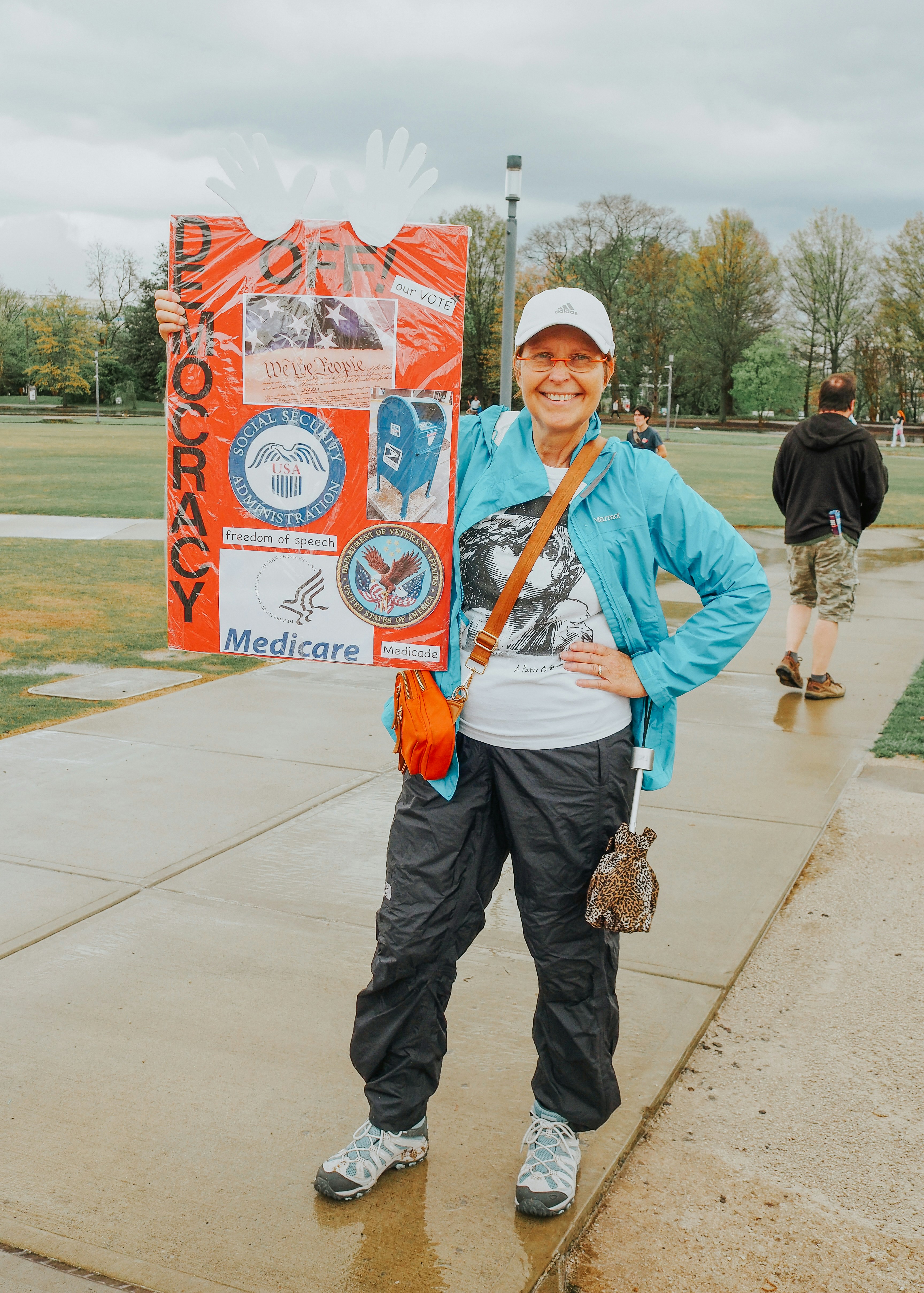 Woman holds a sign about democracy and health
