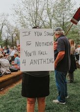 A person holds a sign with a powerful quote.