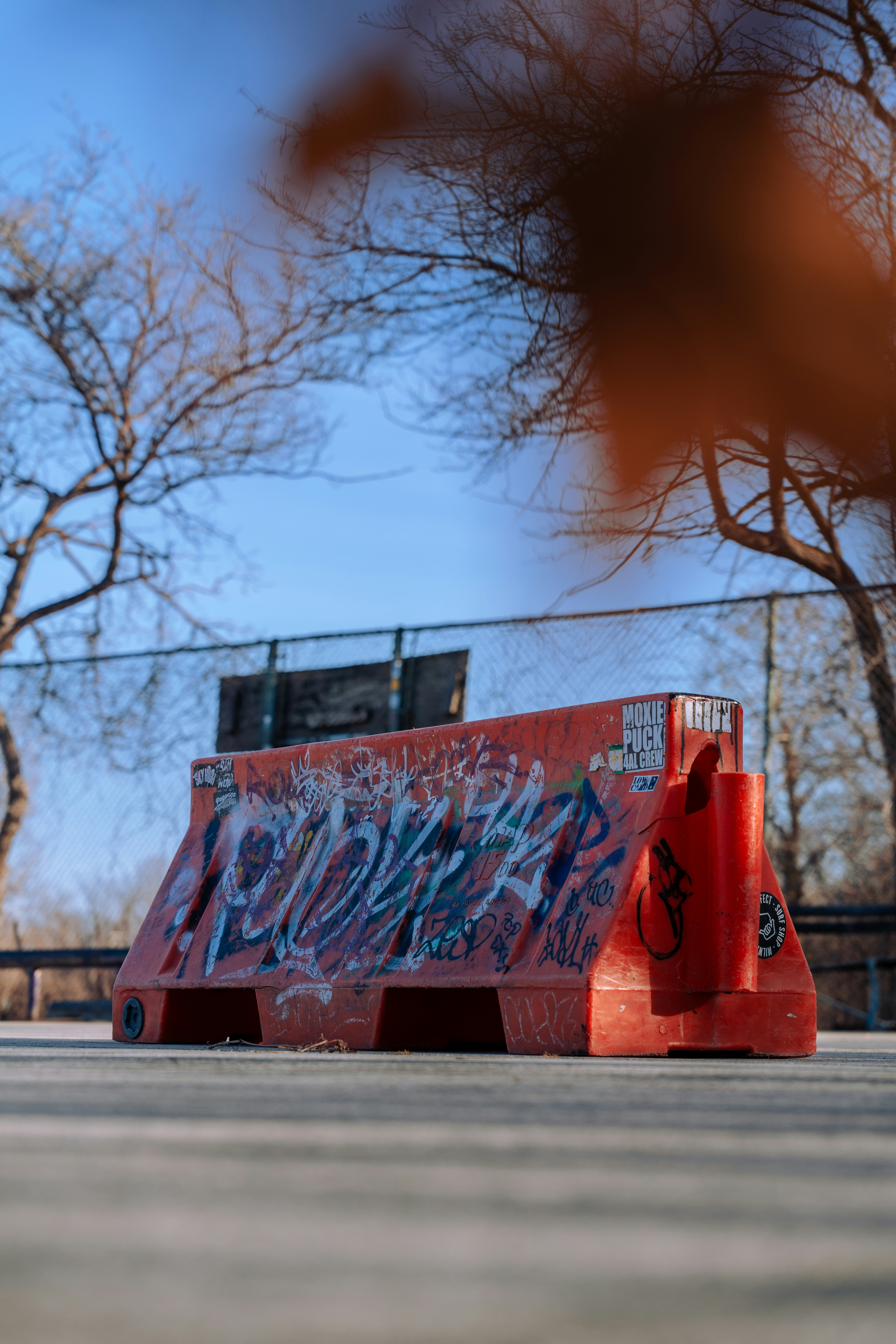 Red barrier with graffiti stands outdoors.