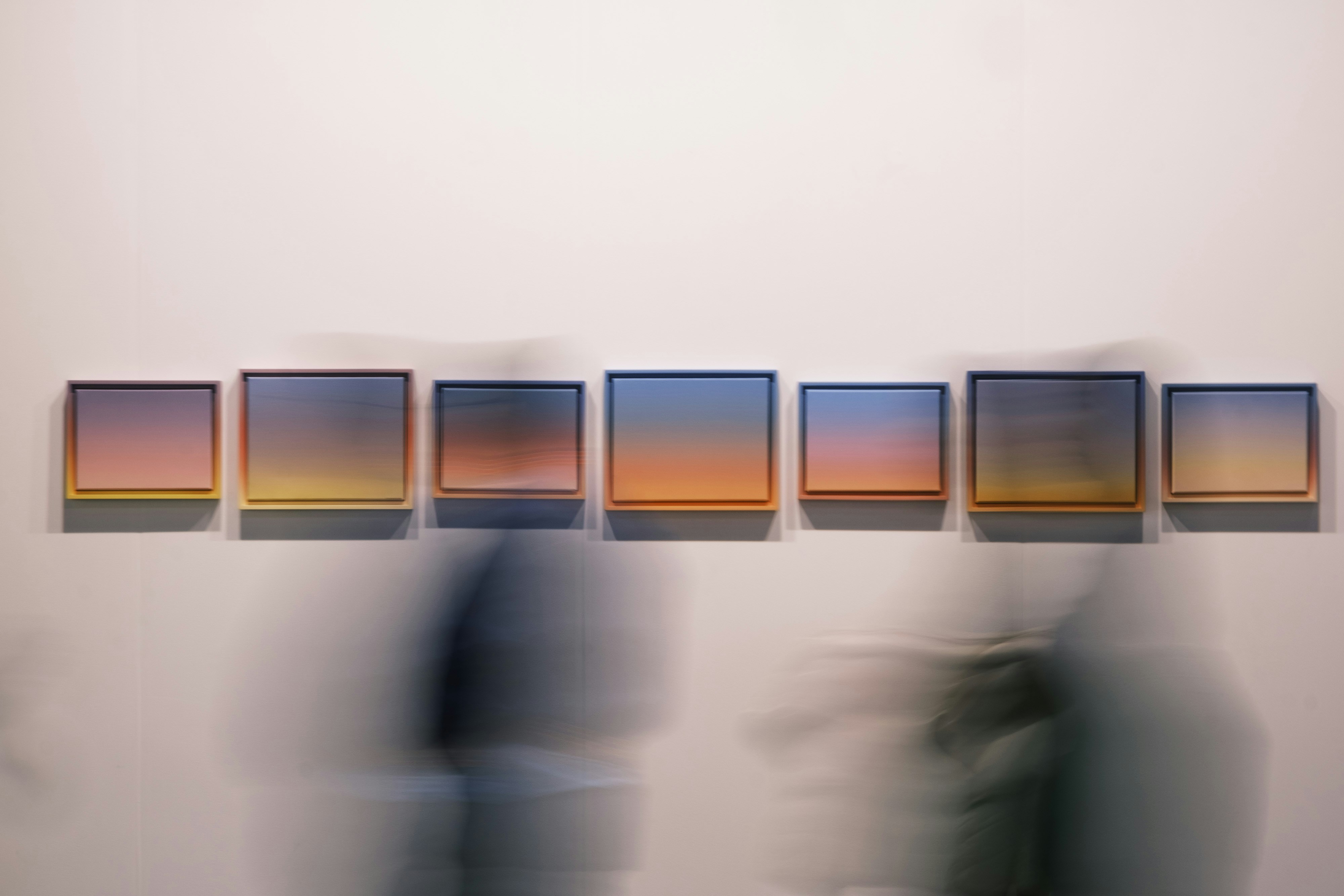 Cuadros de cielos cuelgan en fila.