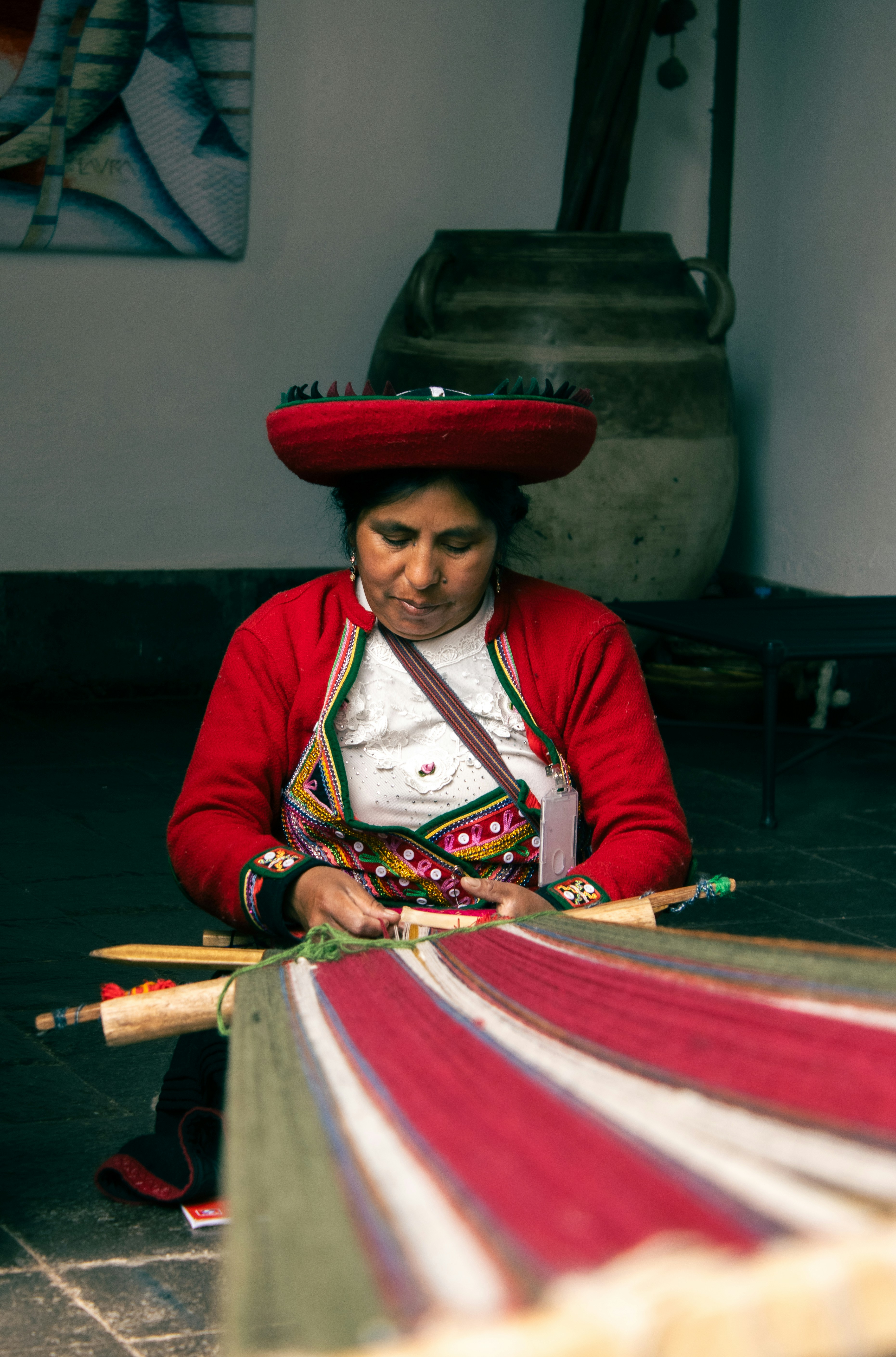 Woman in traditional dress weaves on a loom.