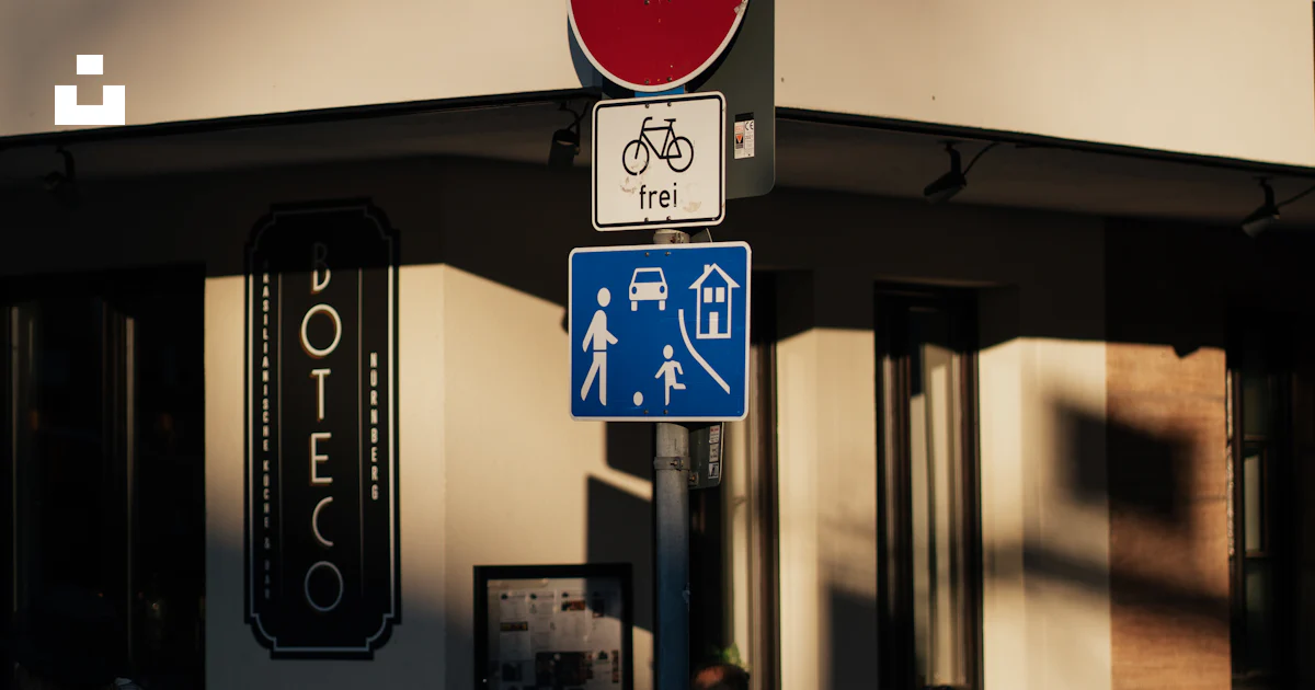 Corner Building Sign Example A corner building displays road signs, with people. photo – Free Woman ...