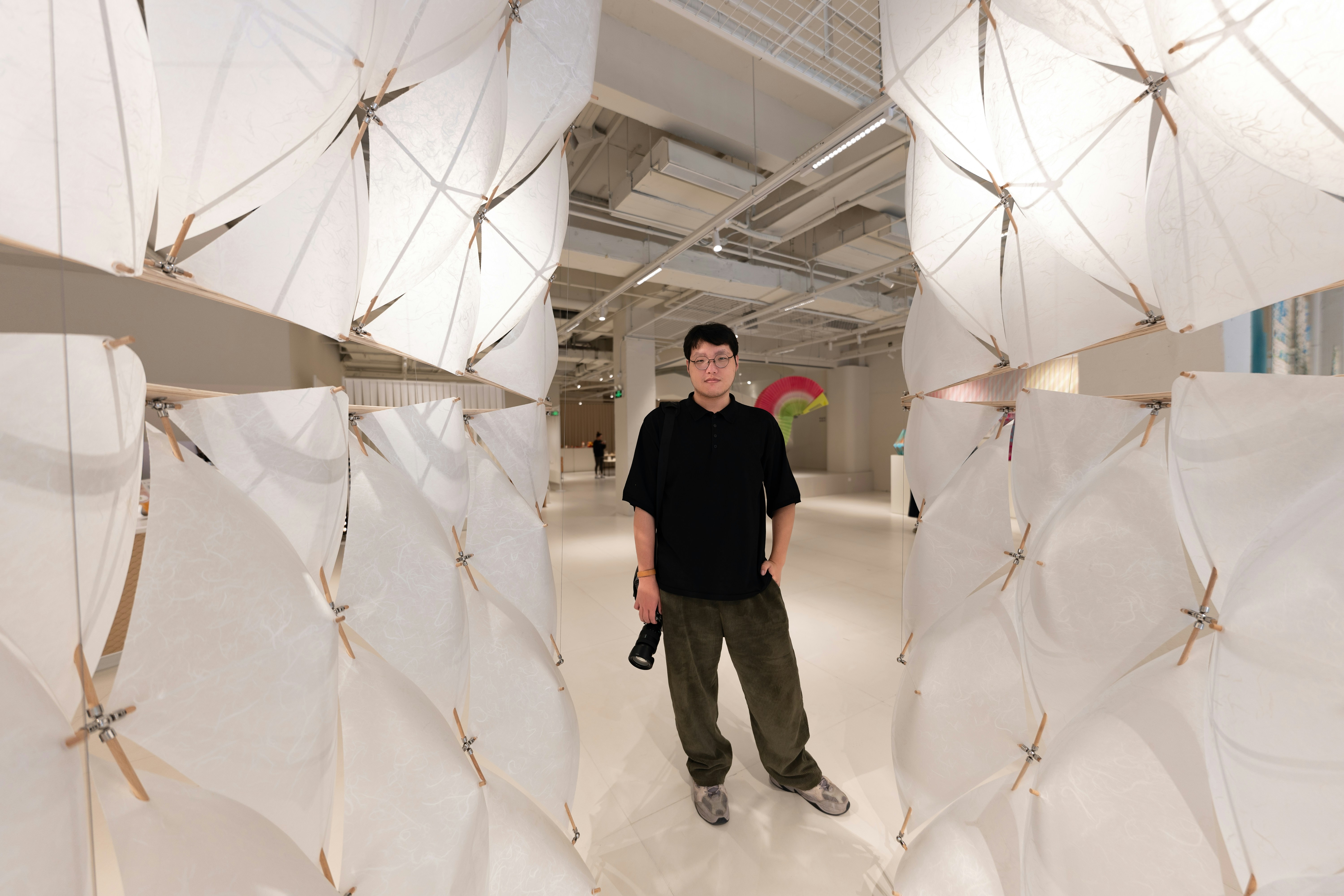 Man stands amid geometric art installations.