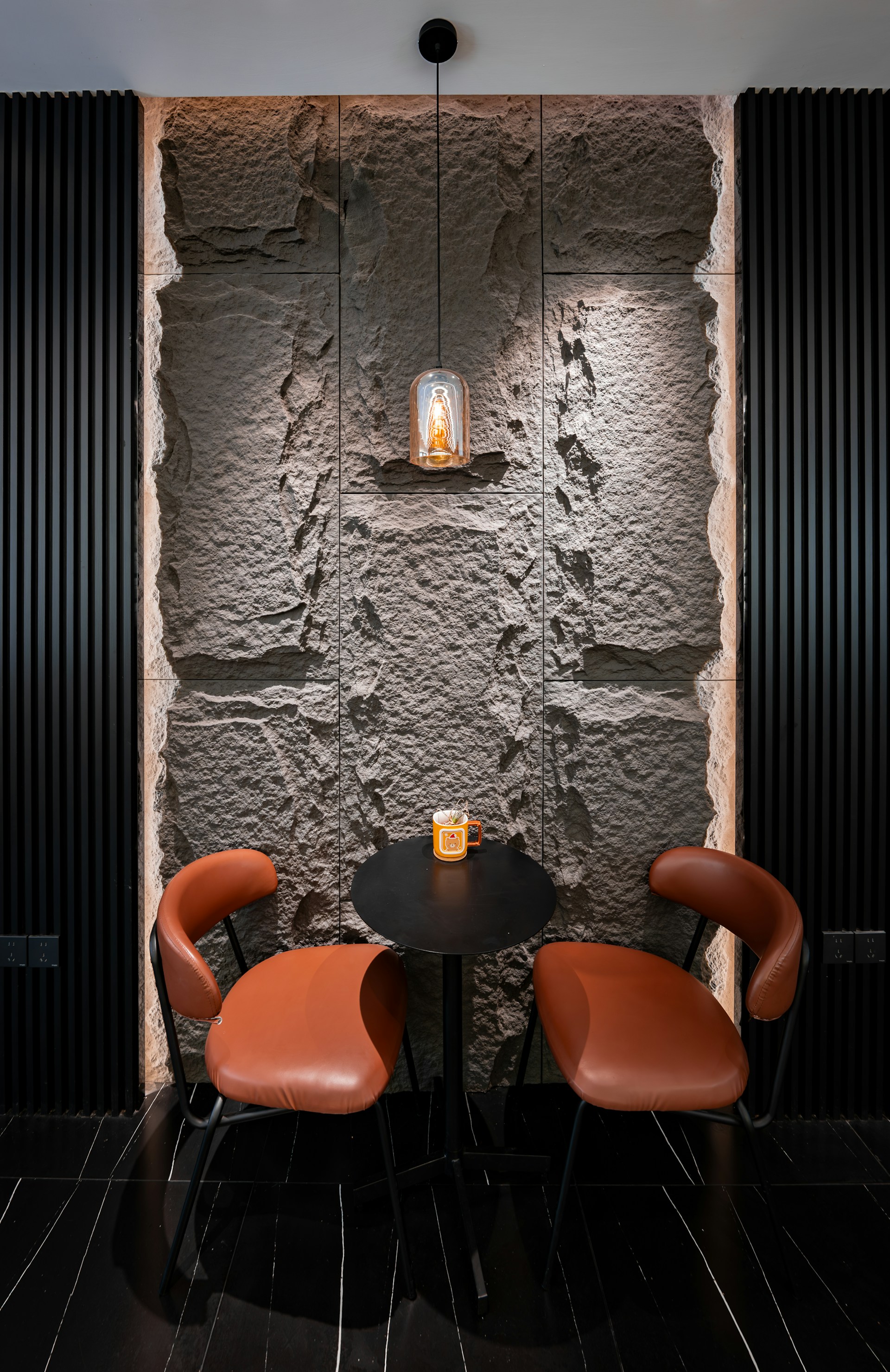 Cozy seating area with stone wall and ambient lighting.