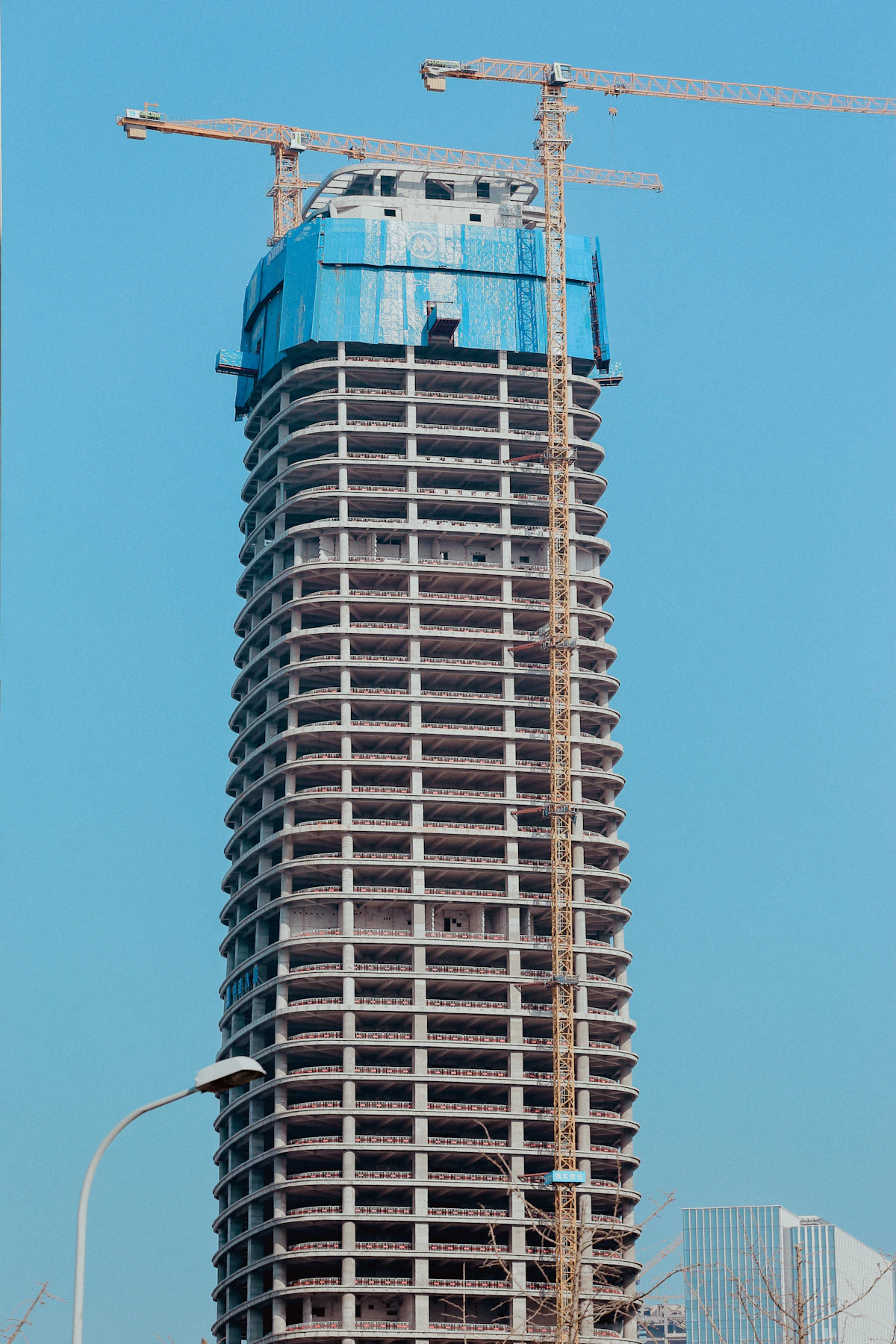 Stock photograph of a tall building under construction with tower cranes
