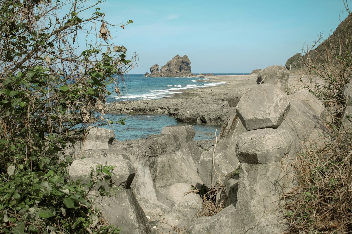 台東蘭嶼海邊的消波塊與海蝕平台，遠處是突出海面的礁岩