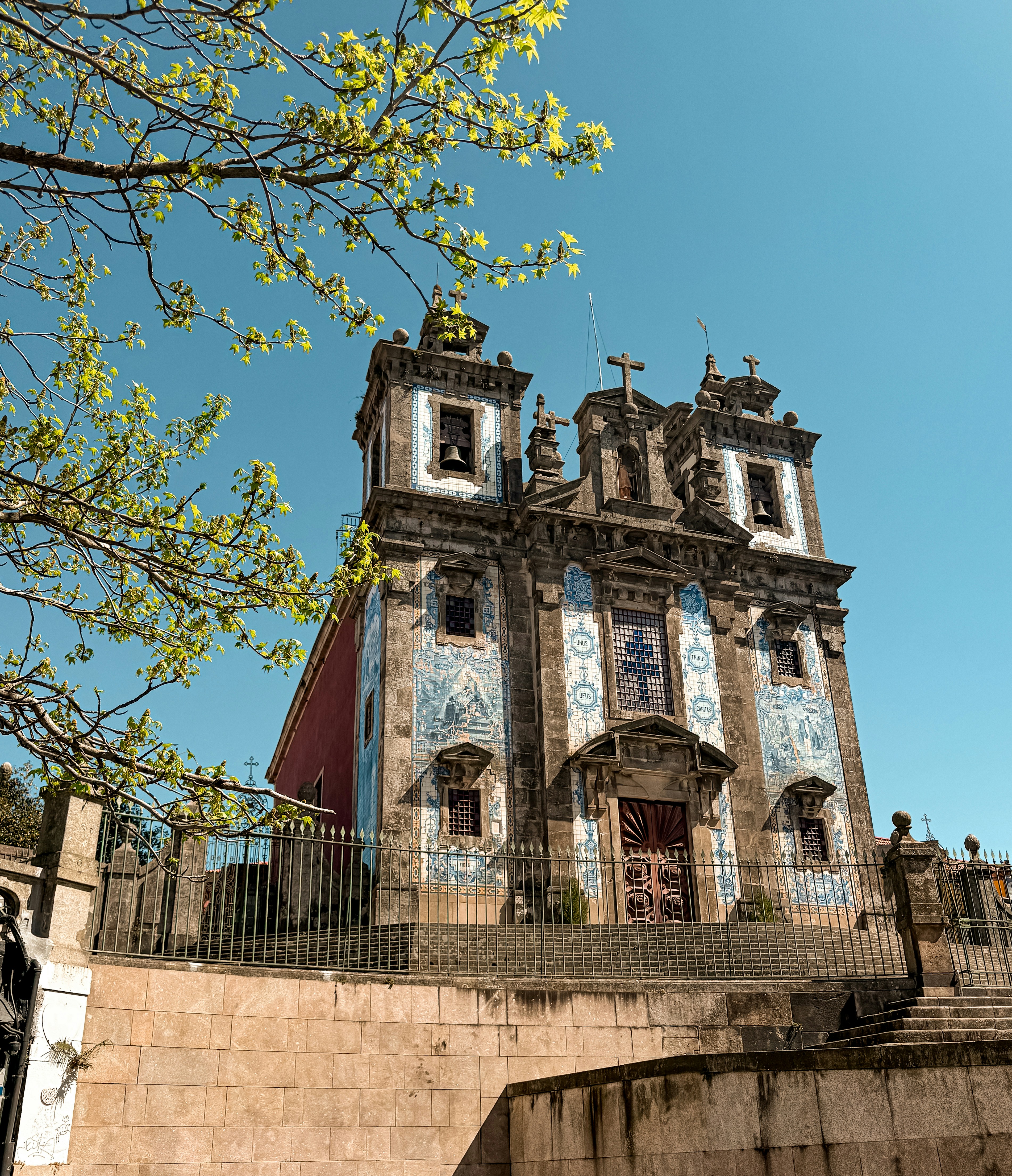Uma igreja com azulejos azuis ergue-se sob o céu azul.