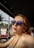 A woman wearing sunglasses looks off to the side.